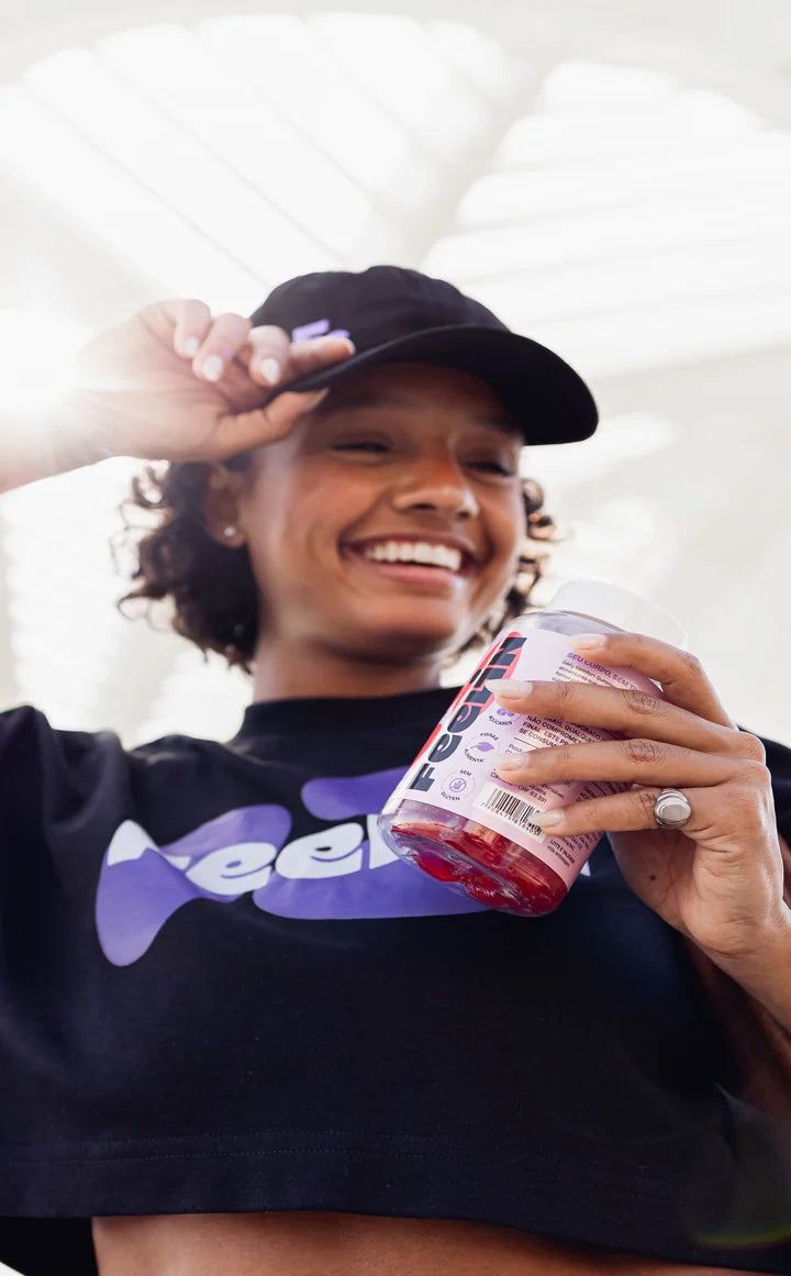 Mulher de boné e camiseta Feelin segurando o pote